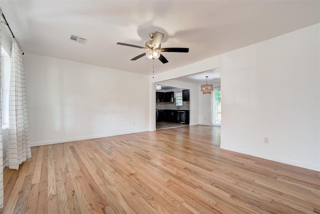 unfurnished living room with light hardwood / wood-style flooring and ceiling fan