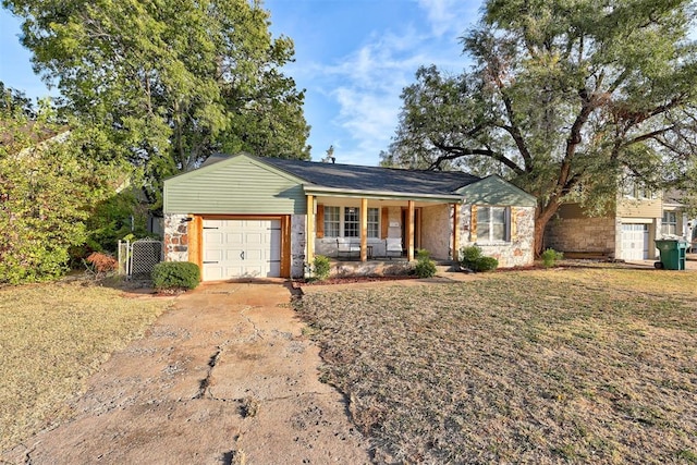 ranch-style house with a garage, covered porch, and a front yard