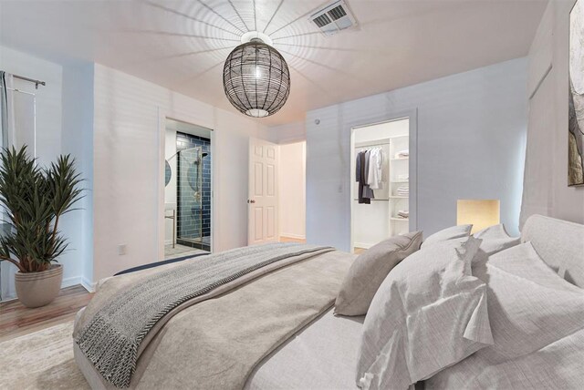 bedroom featuring ensuite bathroom and light hardwood / wood-style flooring