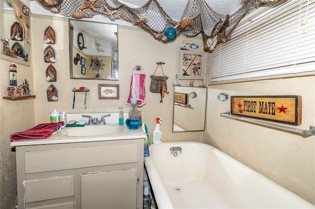 bathroom featuring a washtub and vanity