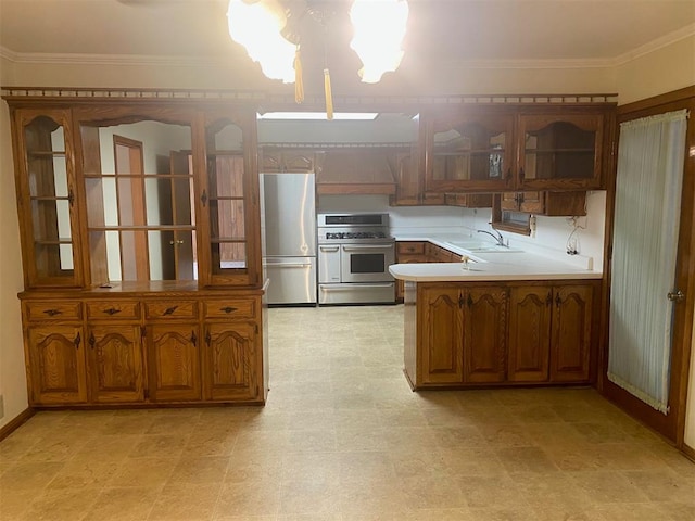 kitchen with kitchen peninsula, crown molding, sink, and appliances with stainless steel finishes