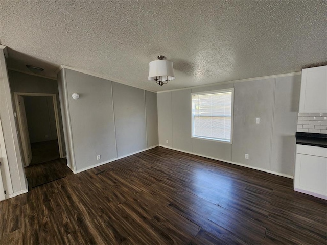 unfurnished living room with dark wood-type flooring and a textured ceiling