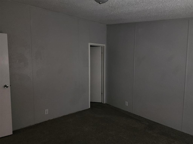 carpeted empty room featuring a textured ceiling