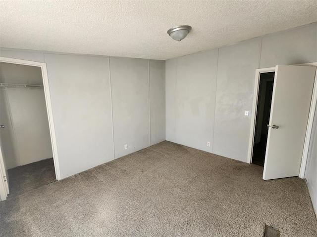 unfurnished bedroom with a textured ceiling and carpet floors