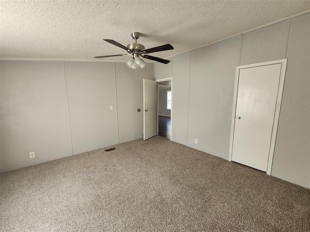 unfurnished bedroom featuring carpet, a textured ceiling, and ceiling fan