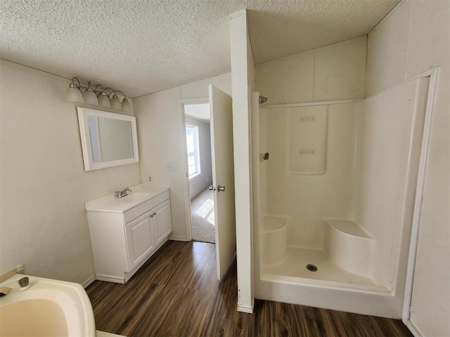 bathroom featuring a shower, hardwood / wood-style floors, and a textured ceiling