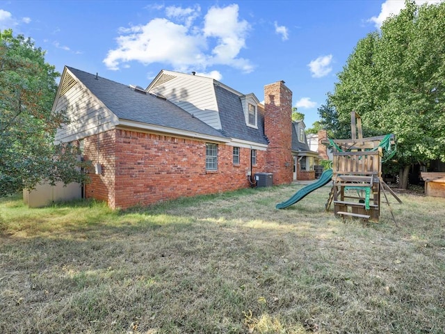 rear view of house featuring a playground, a yard, and cooling unit