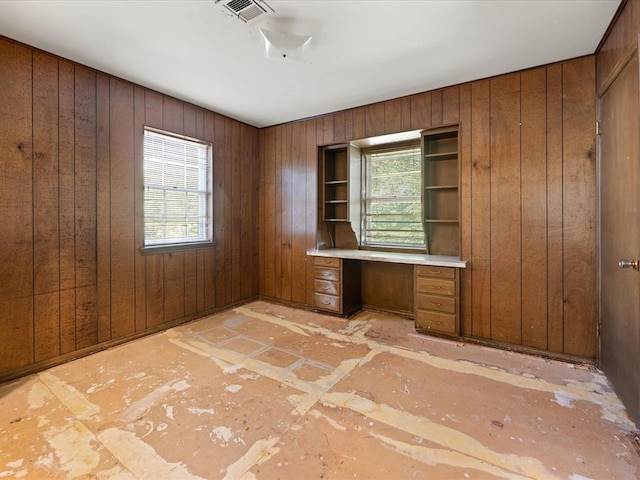 unfurnished office with wood walls and built in desk