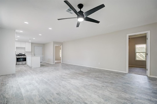 unfurnished living room with ceiling fan and light wood-type flooring