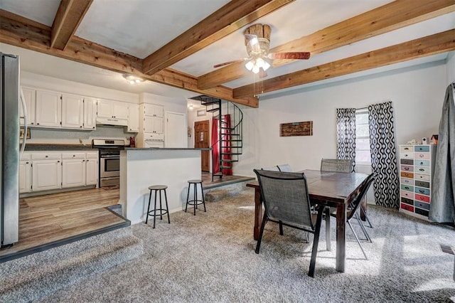 dining space with beamed ceiling, ceiling fan, and light wood-type flooring