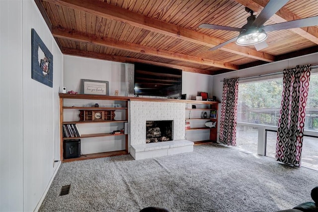 unfurnished living room with ceiling fan, a fireplace, beamed ceiling, and wood ceiling