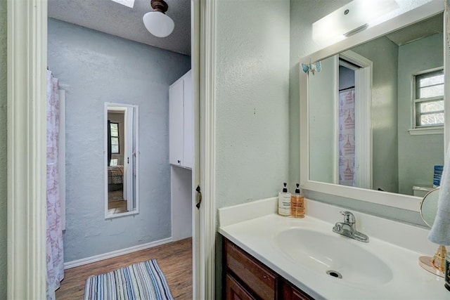 bathroom with hardwood / wood-style floors, vanity, and a textured ceiling