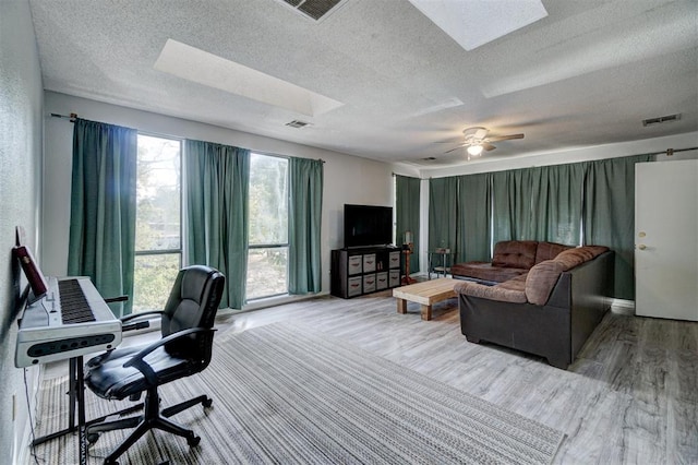 office space featuring a textured ceiling, light hardwood / wood-style floors, and ceiling fan