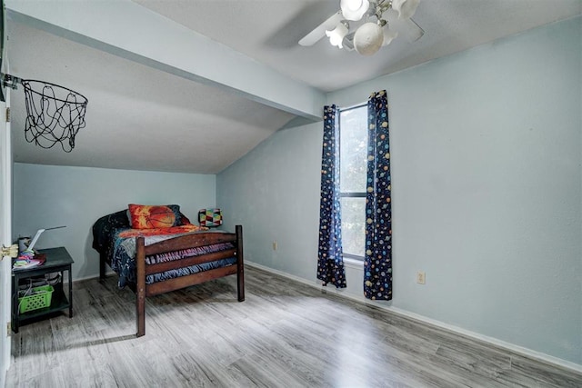 bedroom with ceiling fan, lofted ceiling with beams, and hardwood / wood-style flooring