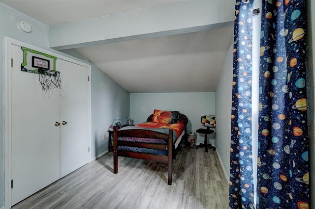 bedroom featuring light hardwood / wood-style floors and lofted ceiling