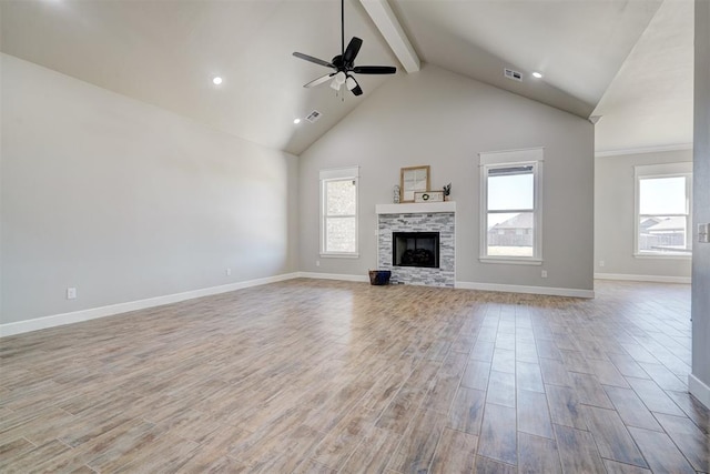 unfurnished living room featuring a fireplace, light hardwood / wood-style floors, high vaulted ceiling, and plenty of natural light