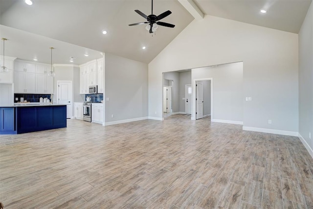 unfurnished living room featuring beam ceiling, high vaulted ceiling, light hardwood / wood-style flooring, and ceiling fan