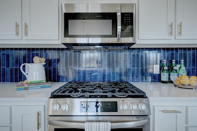 kitchen with white cabinets, stainless steel appliances, and tasteful backsplash