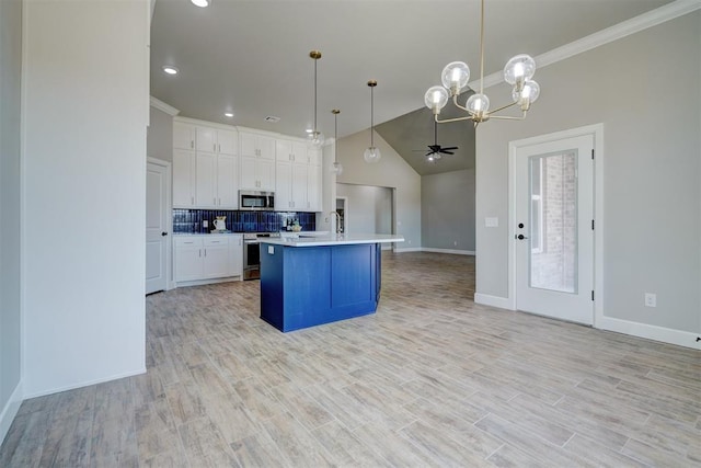 kitchen featuring white cabinetry, hanging light fixtures, a center island with sink, ceiling fan with notable chandelier, and appliances with stainless steel finishes