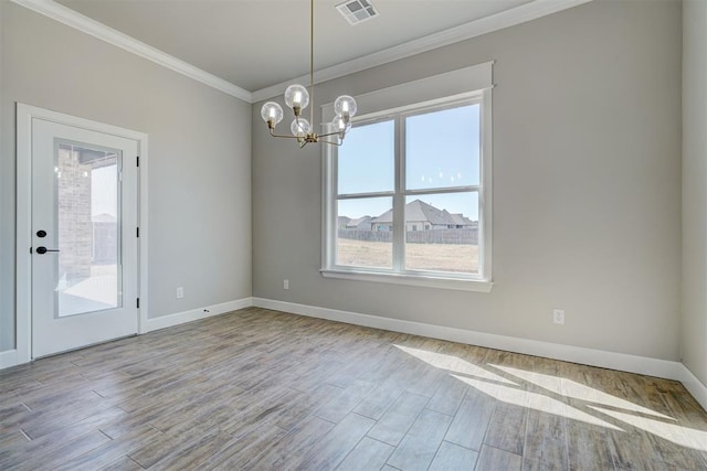 empty room featuring a chandelier, light hardwood / wood-style flooring, and ornamental molding