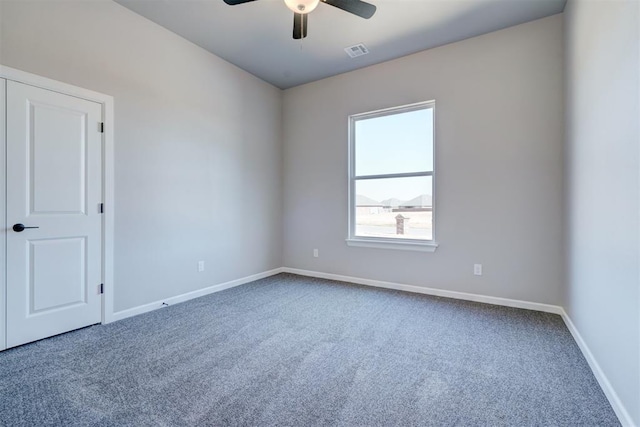 spare room featuring ceiling fan and carpet floors