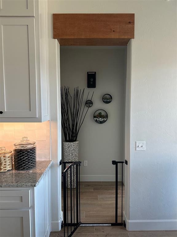 interior space with decorative backsplash and hardwood / wood-style flooring