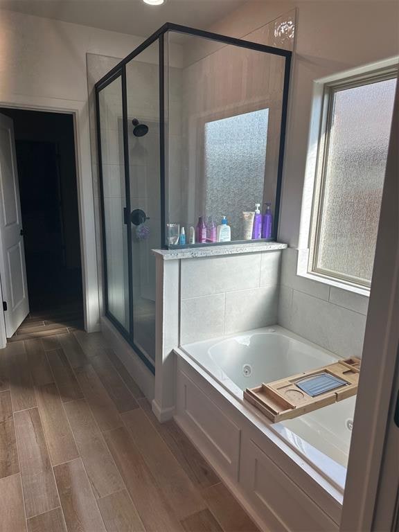 bathroom with plus walk in shower and hardwood / wood-style flooring