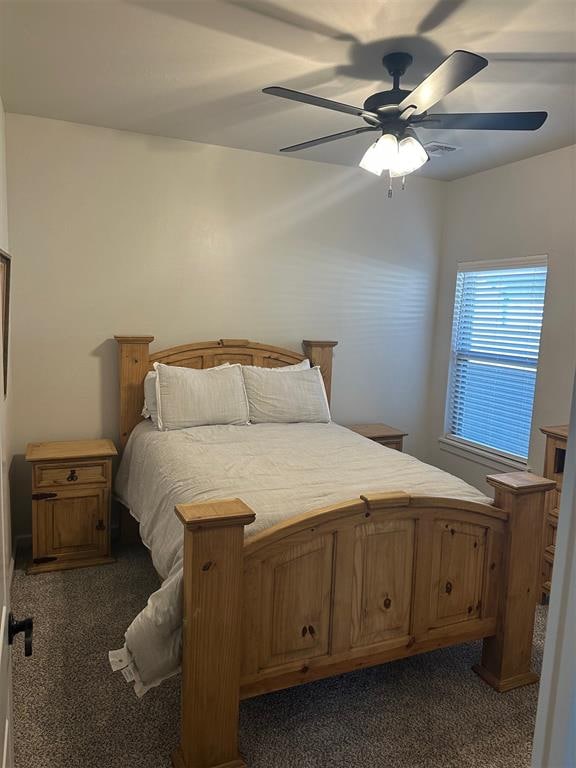 bedroom with dark colored carpet and ceiling fan