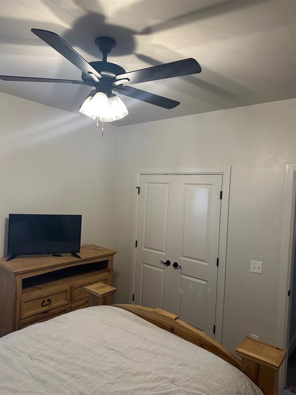 bedroom with ceiling fan and a closet