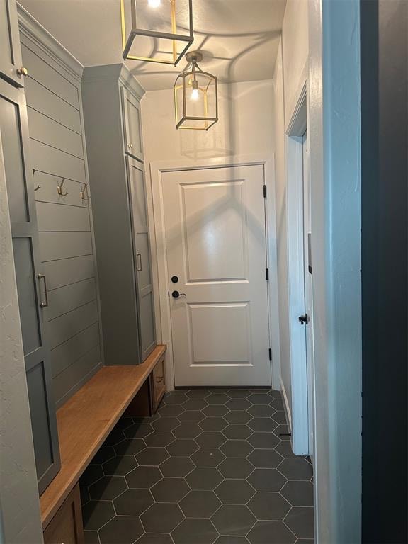 mudroom with dark tile patterned floors