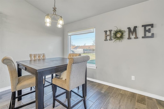 dining space with hardwood / wood-style flooring and a notable chandelier