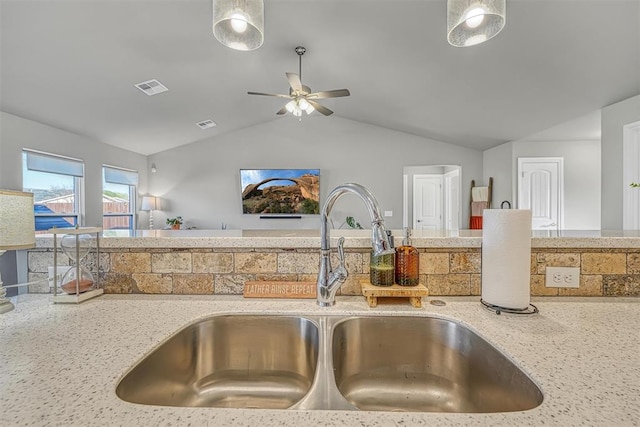 kitchen with light stone counters, sink, ceiling fan, and lofted ceiling