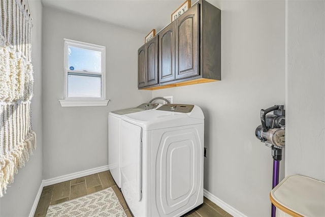 clothes washing area with dark hardwood / wood-style flooring, cabinets, and independent washer and dryer