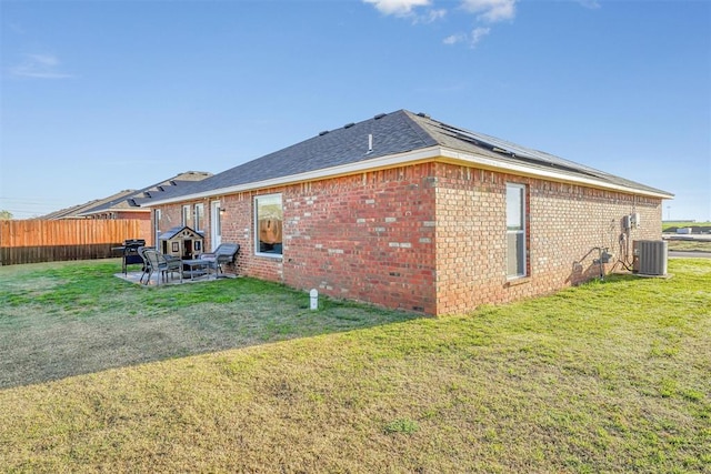 view of side of property with cooling unit, a patio area, and a lawn