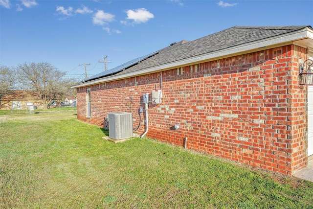 view of property exterior featuring solar panels, a lawn, and central air condition unit