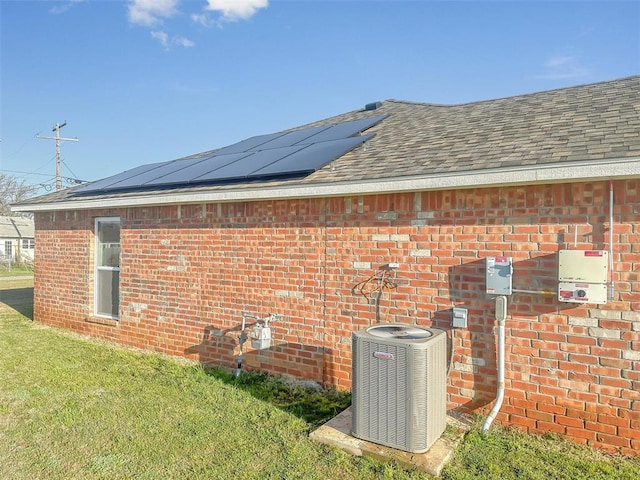 view of property exterior featuring solar panels, a yard, and central AC unit