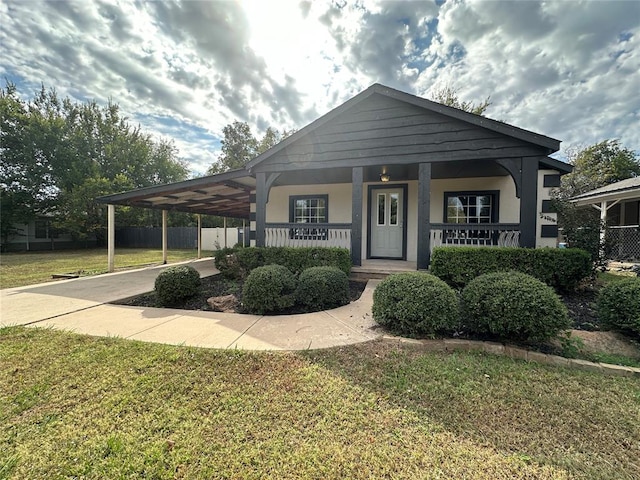 view of front of property with a front lawn, covered porch, and a carport