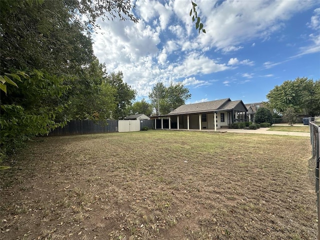 view of yard with a storage shed and a sunroom