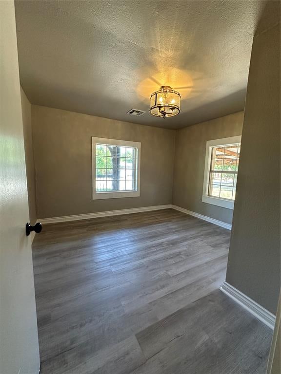 spare room featuring hardwood / wood-style floors and a textured ceiling