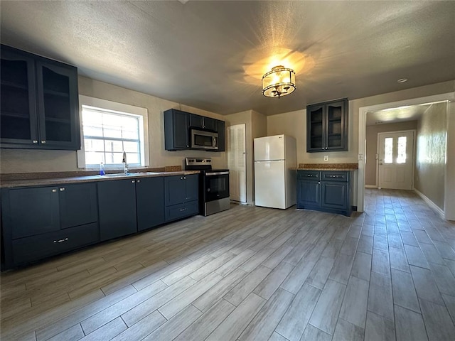 kitchen with sink, a healthy amount of sunlight, light wood-type flooring, and appliances with stainless steel finishes