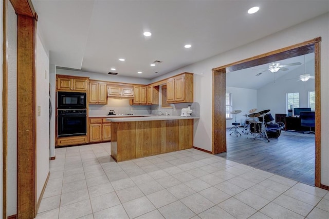 kitchen with ceiling fan, light hardwood / wood-style flooring, kitchen peninsula, lofted ceiling, and black appliances