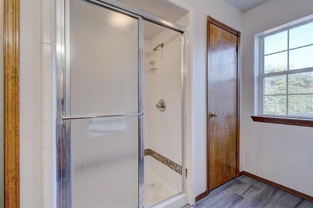 bathroom featuring a shower with door and hardwood / wood-style flooring