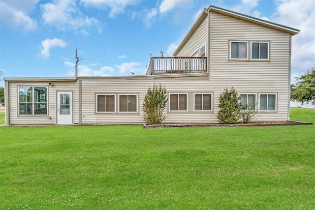 back of property featuring a lawn and a balcony