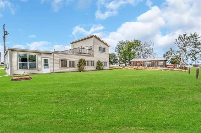 back of property with a yard and a balcony