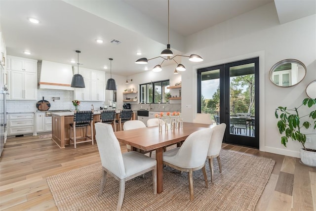 dining room with french doors and light hardwood / wood-style flooring