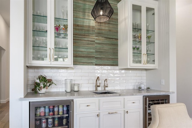 bar featuring backsplash, white cabinetry, sink, and wine cooler