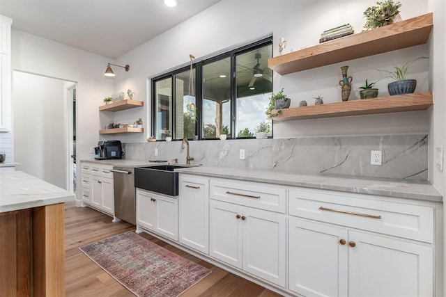 kitchen featuring light stone countertops, dishwasher, sink, decorative backsplash, and white cabinets