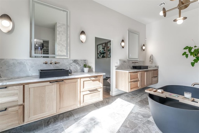 bathroom featuring decorative backsplash, vanity, and a chandelier