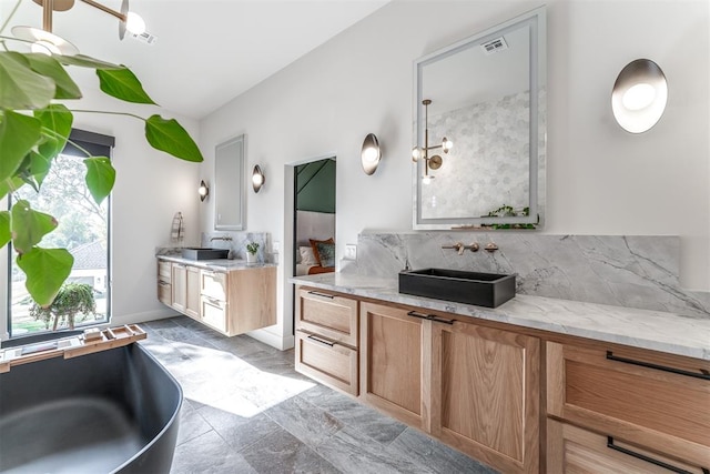 bathroom with decorative backsplash, vanity, and an inviting chandelier