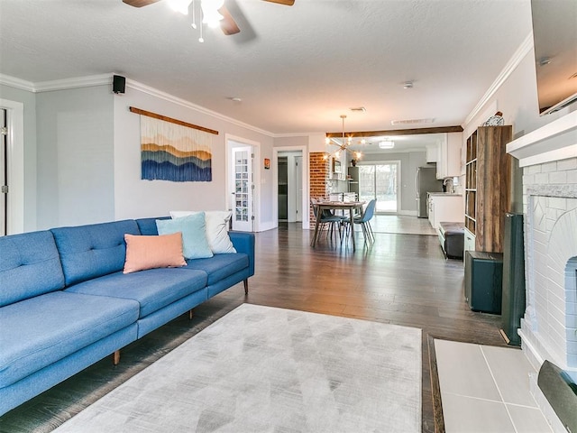 living room featuring ceiling fan with notable chandelier, dark hardwood / wood-style floors, and crown molding